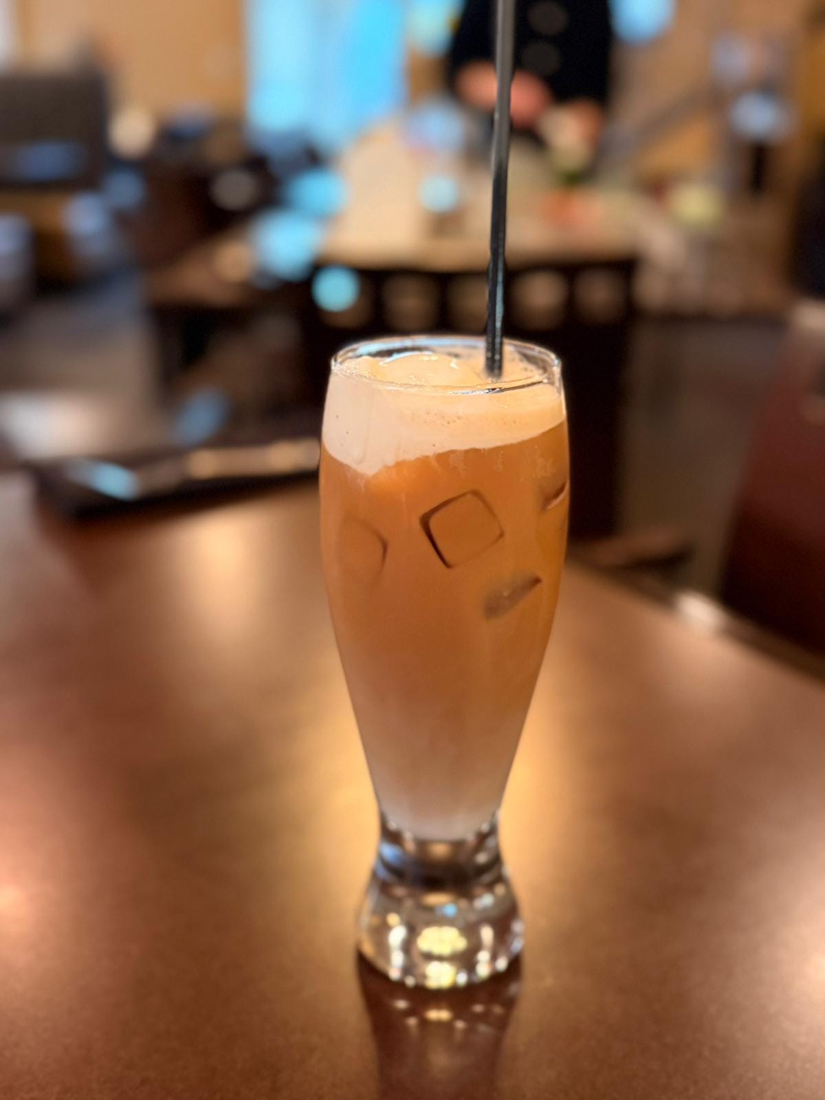Iced nitro cold brew coffee in a tall glass with a smooth, creamy head